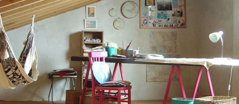 Hipster home office. Desk with pink legs and pink chair. Hammock in the corner.